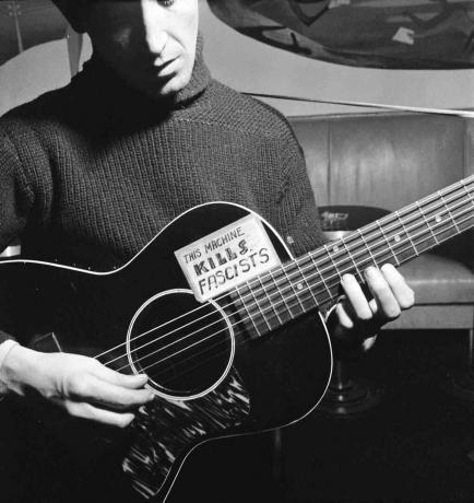 Woody Guthrie hrající na kytaru