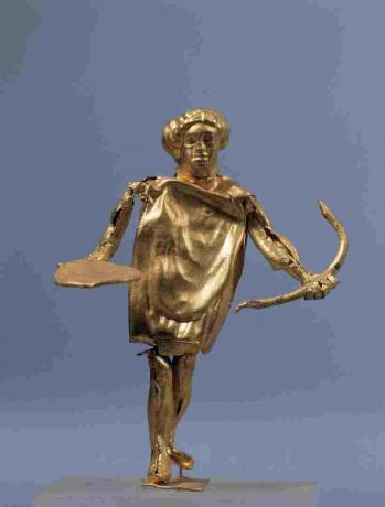 Zlatá socha Apolla s lukem na displeji v řeckém muzeu umění.