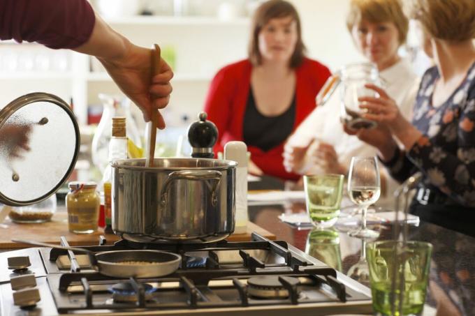 Míchání hrnce na sporáku na kuchyňském ostrově umožňuje interakci s hosty večeře.