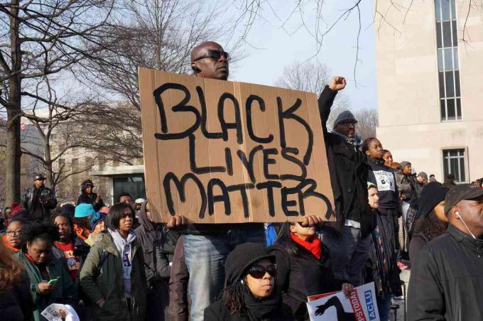 Muž protestující proti smrti Michaela Browna, Erica Garnera a Tamira Ricee zobrazuje ve Washingtonu DC záležitost Black Lives.