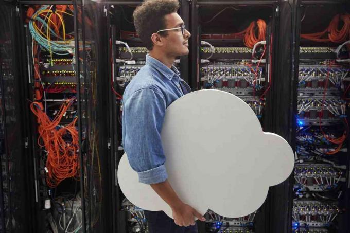 Mužské IT technik nesoucí cloud v serverové místnosti, cloud computing