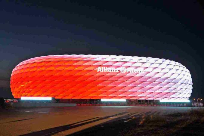 bílá ve dne, vyřezávaný exteriér Allianz Arena v noci svítí červeně