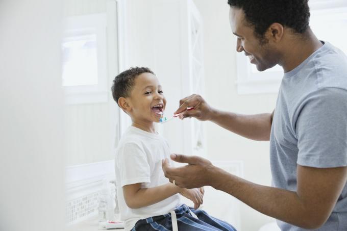 Šťastný otec, čištění zubů syna v koupelně
