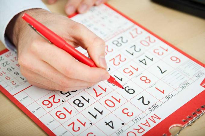 Mano acciendo fecha sobre calendario.