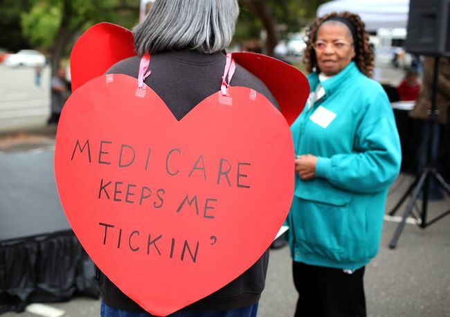 Žena s nápisem ve tvaru srdce s nápisem „Medicare mě drží tikání“