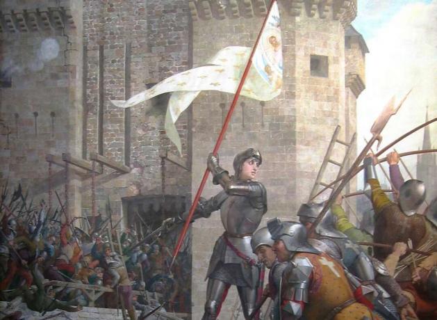 Joan z Arku v brnění mává bílou a zlatou vlajkou před vojáky.