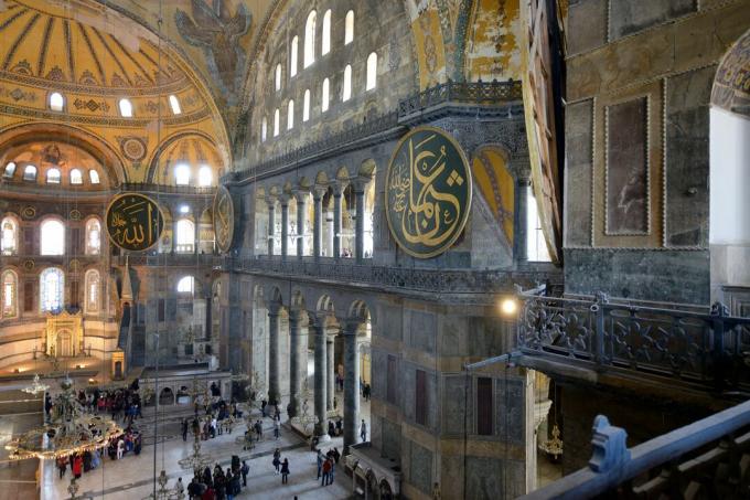 masivní vnitřní prostor vysoký 180 stop obklopený klenutými okny, mozaikami a obrovskou kupolí s přívěsky
