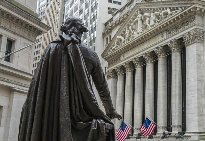 Socha George Washington se dívá směrem k newyorské burze cenných papírů na Broad Street z Federal Hall National Memorial na Wall Street v New Yorku.