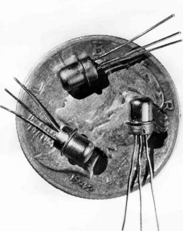Obrázek z roku 1956 tří miniaturních tranzistorů M-1 viděných na tváři desetníku