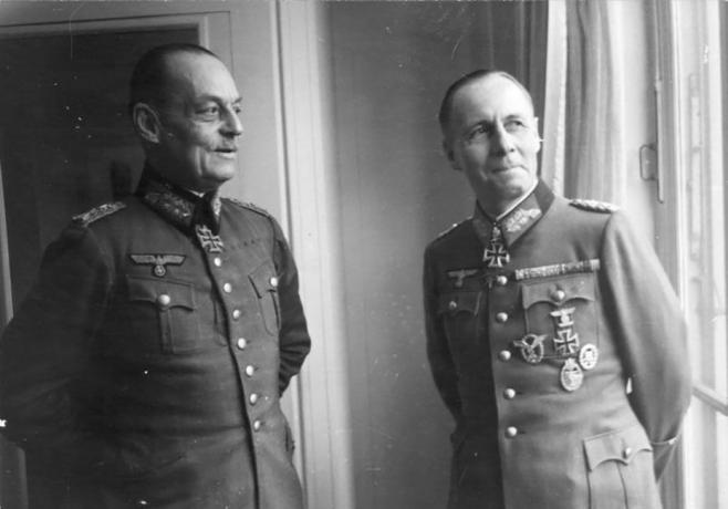 Gerd von Rundstedt a Erwin Rommel v německých vojenských uniformách stojící u okna.