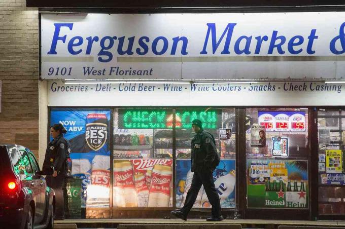 Policejní důstojníci před Ferguson Market & Liquor během nepokojů v roce 2014 ve Fergusonu v Missouri.