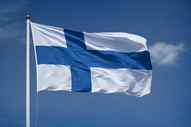 Vztyčená finská vlajka s pozadím modré oblohy