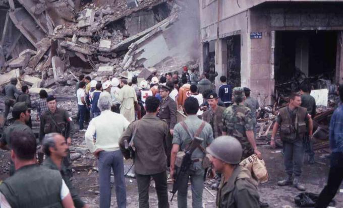 Dav ničitelů a pomocných dárců stojí uprostřed ničení a poškození na místě sebevražedného bombového útoku na americké velvyslanectví, Bejrút, Libanon, 18. dubna 1983.