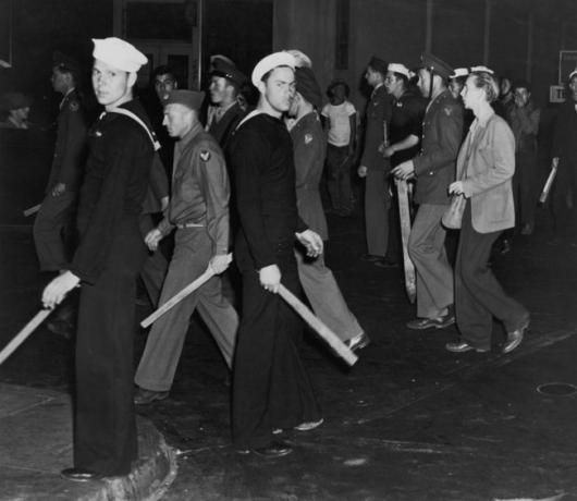 Gangy amerických námořníků a námořní pěchoty vyzbrojené holemi během Zoot Suit Riots, Los Angeles, Kalifornie, červen 1943.