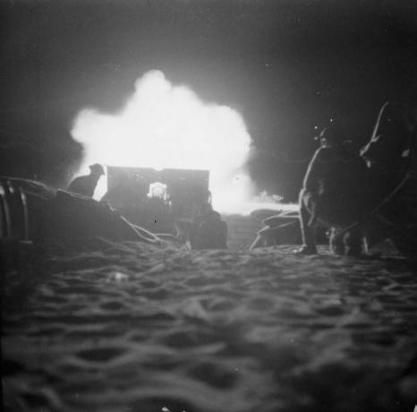 Fotografie dělostřelecké figurky střílející v noci.